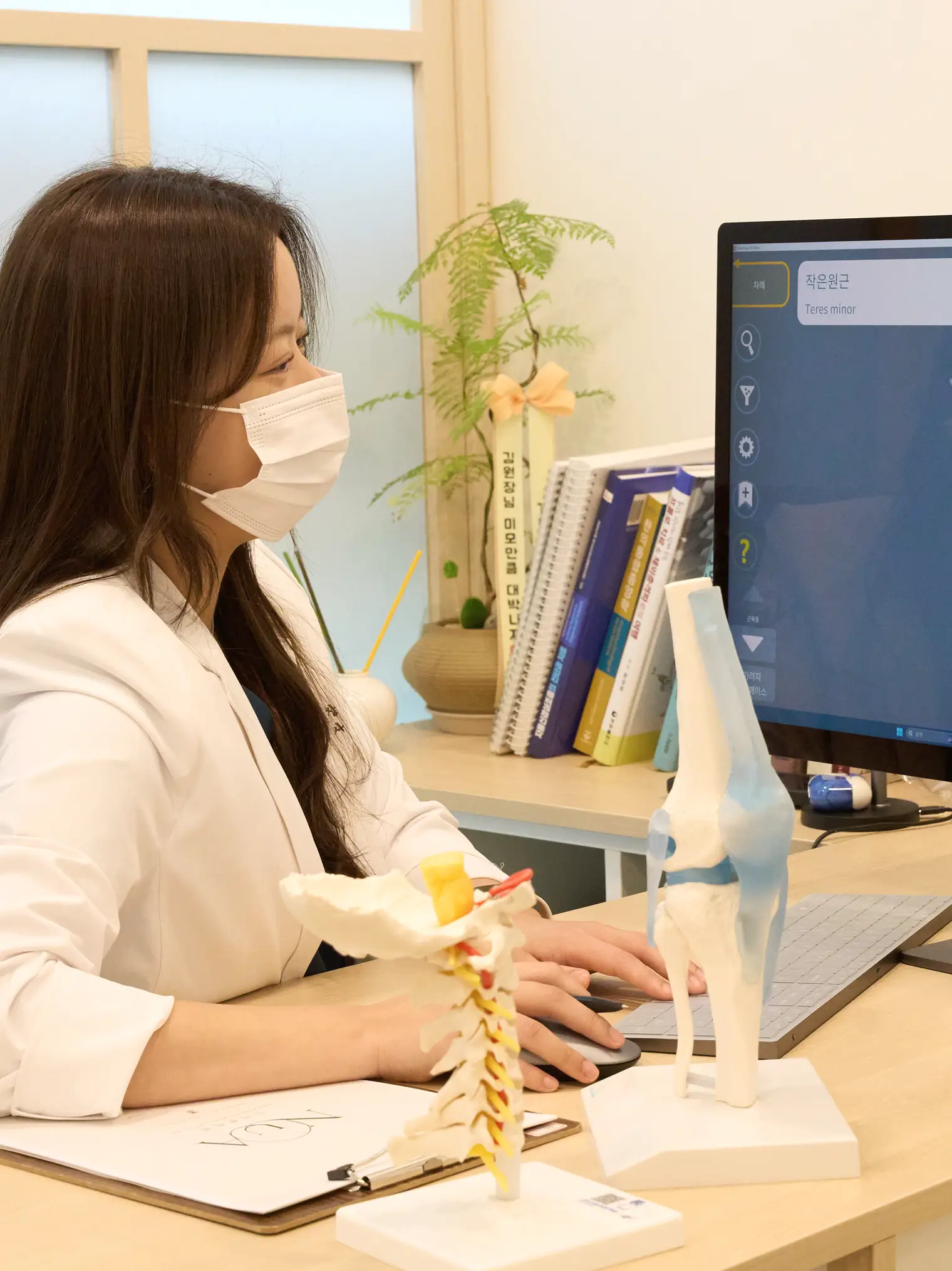 모니터의 해부 그림을 보며 환자에게 설명하는 김정현 원장